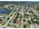 Wide aerial view of the neighborhood with many homes, a lake, and the subject property marked with a red arrow at 1301 Flaxwood Ave, Brandon, FL 33511