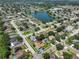 Aerial shot showcases a home with a blue driveway nestled in a neighborhood with a nearby lake at 1301 Flaxwood Ave, Brandon, FL 33511