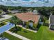 Aerial view of a yellow home with a large yard, a swimming pool, and a driveway with blue coating at 1301 Flaxwood Ave, Brandon, FL 33511