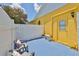 Sunny backyard patio with a white fence, two chairs with cushions and an air conditioning unit at 1301 Flaxwood Ave, Brandon, FL 33511