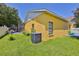Exterior view of yellow house showing fenced in patio, lawn and air conditioning unit at 1301 Flaxwood Ave, Brandon, FL 33511