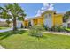 Charming yellow home with a well-manicured lawn, complemented by a palm tree and decorative white picket fence at 1301 Flaxwood Ave, Brandon, FL 33511