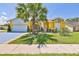 Charming yellow single-story home with a well-manicured lawn and vibrant landscaping at 1301 Flaxwood Ave, Brandon, FL 33511