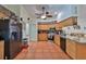 The kitchen features tile floors, wooden cabinetry, a stainless steel refrigerator, and black appliances at 1301 Flaxwood Ave, Brandon, FL 33511
