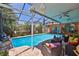 Inviting screened-in pool with adjacent patio, comfortable outdoor seating and mature landscaping at 1301 Flaxwood Ave, Brandon, FL 33511