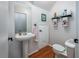 Compact bathroom with a pedestal sink, toilet, and mirrored cabinet at 1304 Kelridge Pl, Brandon, FL 33511
