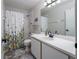 Bathroom with white vanity, marble floors, and shower with floral curtain at 1304 Kelridge Pl, Brandon, FL 33511
