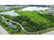 Aerial view of a community lake and boardwalk trail surrounded by lush greenery and walking paths at 13319 Dorado Shores Ave, Riverview, FL 33579