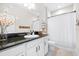 Stylish bathroom featuring dark countertops, white cabinetry, and a shower-tub combination at 13319 Dorado Shores Ave, Riverview, FL 33579
