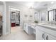 Well-lit bathroom featuring double sinks, granite counters, and access to walk-in closet at 13319 Dorado Shores Ave, Riverview, FL 33579