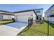Two-story home with a spacious driveway, lush landscaping, fenced backyard, and patio at 13319 Dorado Shores Ave, Riverview, FL 33579