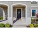 Inviting front porch featuring an arched entryway, decorative wreath, and views of manicured landscaping at 13319 Dorado Shores Ave, Riverview, FL 33579