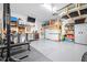 Organized garage featuring work bench, television, storage shelves, gym and epoxy flooring for a clean look at 13319 Dorado Shores Ave, Riverview, FL 33579
