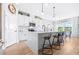 Bright kitchen features white cabinetry, a quartz island with seating, and stainless steel appliances with modern light fixtures at 13319 Dorado Shores Ave, Riverview, FL 33579
