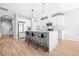 Bright kitchen featuring white cabinetry, a quartz island with seating, and stainless steel appliances with modern light fixtures at 13319 Dorado Shores Ave, Riverview, FL 33579