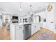 Bright kitchen with white cabinets, quartz countertops, and stainless steel appliances overlooking the living room at 13319 Dorado Shores Ave, Riverview, FL 33579