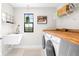 Bright laundry room with sink, wood counter and front load washer and dryer at 13319 Dorado Shores Ave, Riverview, FL 33579