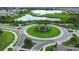 Aerial view of a landscaped roundabout with palm trees within the community near a lake at 13319 Dorado Shores Ave, Riverview, FL 33579