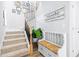 Elegant staircase featuring carpeted steps, dark wrought iron spindles, and a cozy bench for comfortable entry at 13319 Dorado Shores Ave, Riverview, FL 33579