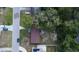 Aerial view of a home with mature trees, a brown roof, and solar panels on an adjacent building at 1345 Springdale St, Clearwater, FL 33755