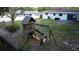 Backyard play area features a wooden playhouse with slide and swing set surrounded by mature trees at 1345 Springdale St, Clearwater, FL 33755