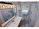 Bright bathroom with a single sink vanity, decorative mirror, and a shower/tub combination with themed curtains at 1345 Springdale St, Clearwater, FL 33755