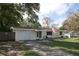 Charming one-story home with a well-manicured lawn and an attached garage, displaying the American flag at 1345 Springdale St, Clearwater, FL 33755