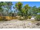 Spacious backyard featuring a newly installed wooden fence and lush trees at 1410 San Charles Dr, Dunedin, FL 34698