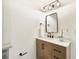 Updated bathroom vanity with modern light fixtures and decorative mirror at 1410 San Charles Dr, Dunedin, FL 34698