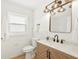 Bright bathroom features a modern vanity, decorative mirror and lighting, and white tiled walls at 1410 San Charles Dr, Dunedin, FL 34698