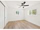 A bright bedroom with a ceiling fan, windows, and wood-look floors at 1410 San Charles Dr, Dunedin, FL 34698
