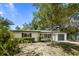 Charming single-story home with a well-manicured lawn, inviting blue front door, and convenient garage at 1410 San Charles Dr, Dunedin, FL 34698