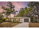 Charming single-story home with a well-manicured lawn, inviting blue front door, and convenient garage at 1410 San Charles Dr, Dunedin, FL 34698