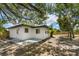 Exterior angle showing the fenced yard, stucco, and multiple windows at 1410 San Charles Dr, Dunedin, FL 34698