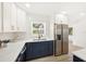 Stylish kitchen with navy blue lower cabinets, white countertops, and stainless steel refrigerator at 1410 San Charles Dr, Dunedin, FL 34698