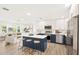 Open concept kitchen with white cabinets, stainless appliances, and breakfast bar that leads to a cozy living room at 1410 San Charles Dr, Dunedin, FL 34698
