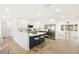 Modern kitchen featuring white cabinetry, stainless steel appliances, and a stylish blue island with bar seating at 1410 San Charles Dr, Dunedin, FL 34698