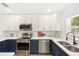 Bright kitchen featuring white cabinets, subway tile backsplash, and stainless steel appliances at 1410 San Charles Dr, Dunedin, FL 34698