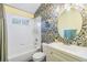 Stylish bathroom with a floral wallpaper and a round mirror at 1419 Trail Boss Ln, Brandon, FL 33511