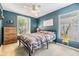 Cozy bedroom featuring blue walls, natural light, and a comfortable bed at 1419 Trail Boss Ln, Brandon, FL 33511