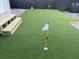 Backyard putting green with synthetic turf and adjacent wooden bench seating area at 1515 E 31St Ave, Tampa, FL 33610