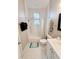 Bright bathroom featuring white hexagon floors, a tub shower, and a window for natural light at 1515 E 31St Ave, Tampa, FL 33610