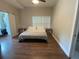 Bedroom with a light gray bedspread, hardwood flooring, a window, and a barn style closet door at 1515 E 31St Ave, Tampa, FL 33610