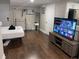 Spacious bedroom area with a large TV, hardwood floors, and clean white walls at 1515 E 31St Ave, Tampa, FL 33610
