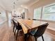 Dining room with a long, natural wood table and modern black chairs and white cabinets at 1515 E 31St Ave, Tampa, FL 33610