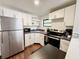 Kitchen featuring white cabinets, stainless steel appliances, and vinyl floors at 1515 E 31St Ave, Tampa, FL 33610