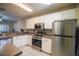 Well-equipped kitchen with stainless steel appliances, white cabinetry, and a tile backsplash at 15733 Fishhawk Falls Dr, Lithia, FL 33547