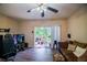 Comfortable living room with wood-look floors, a ceiling fan, and sliding glass doors to a balcony at 15733 Fishhawk Falls Dr, Lithia, FL 33547