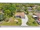Aerial view of a charming single-story home featuring a manicured lawn, a two car garage, and mature landscaping at 2016 Alameda Dr, Spring Hill, FL 34609