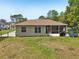 A spacious backyard features green grass, a screened patio, and ample space for outdoor activities at 2016 Alameda Dr, Spring Hill, FL 34609